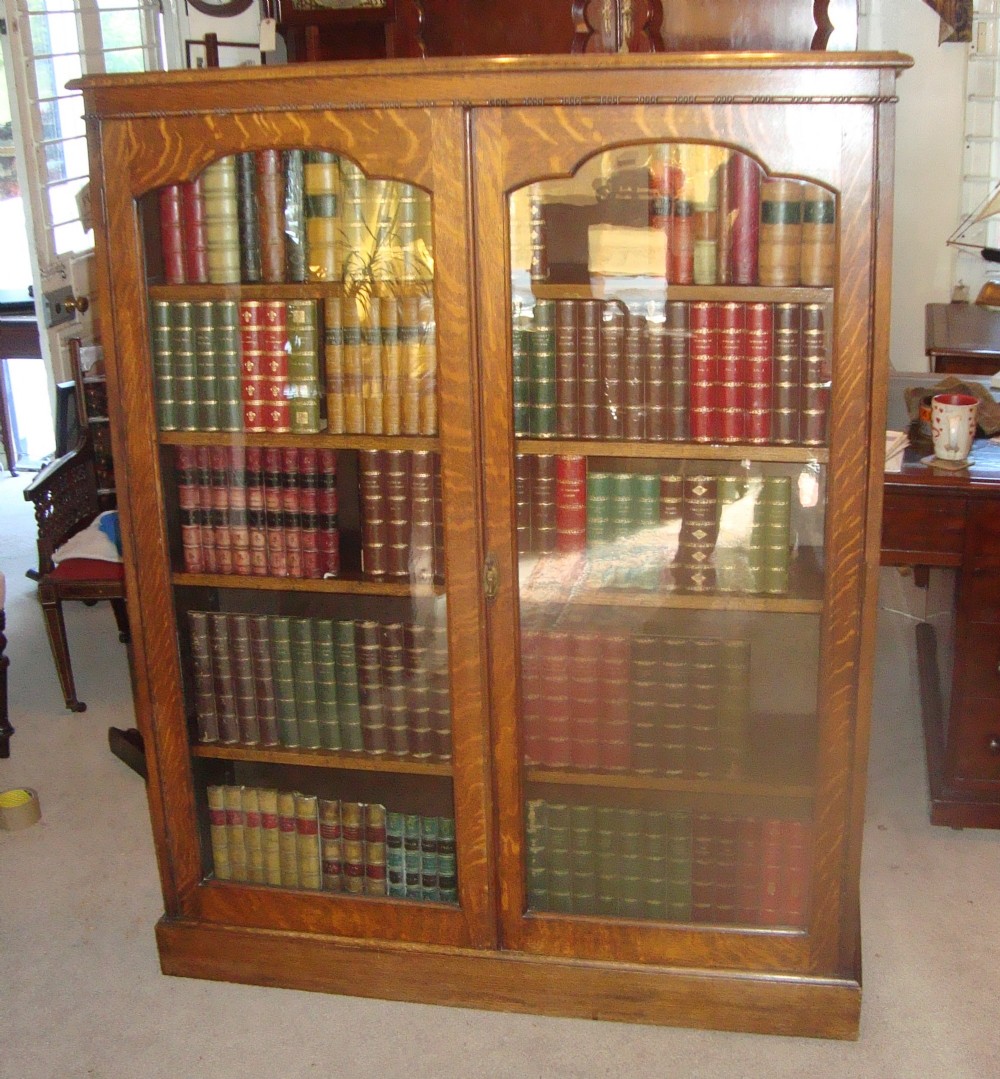 Edwardian solid and golden oak glazed library bookcase. 