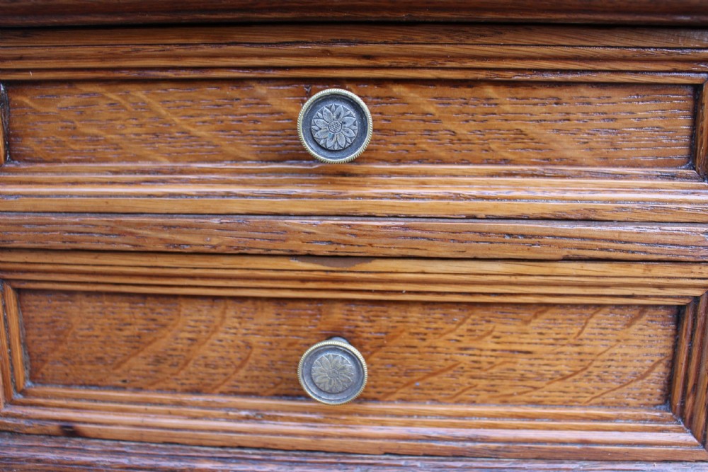 A Victorian golden oak pedestal desk featuring a green leather writing insert, twin pedestals of drawers, brass handles, and a raised top gallery. View II