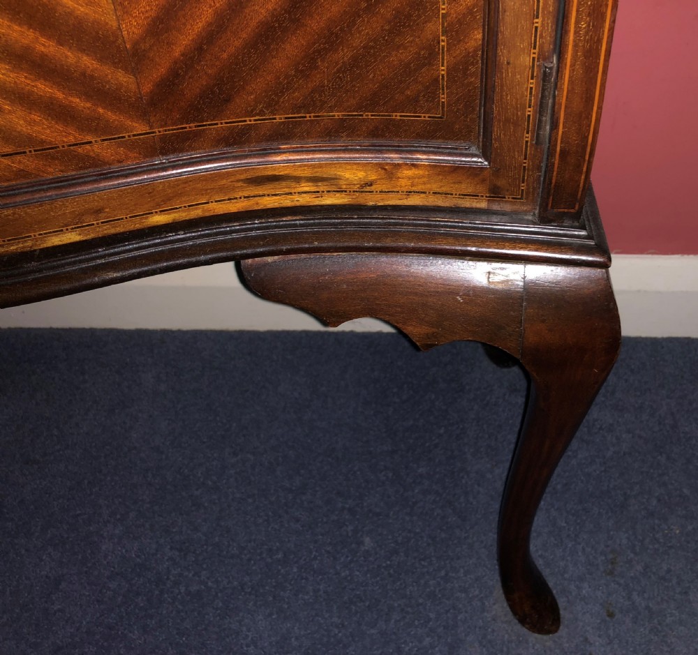 A late Victorian mahogany glazed display cabinet featuring three central glass doors above geometric inlaid timber panels, resting on cabriole legs with a blue fabric-lined interior. View IV