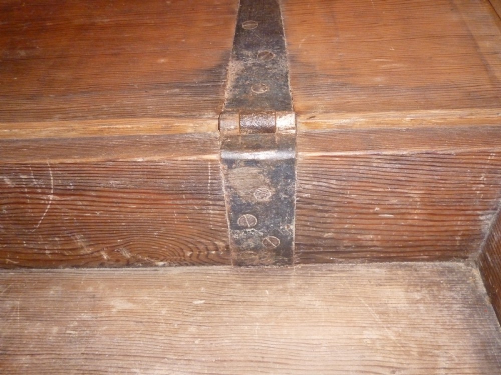A low rectangular solid pine ammunition box featuring dark metal corner brackets and a central front latch. View VI