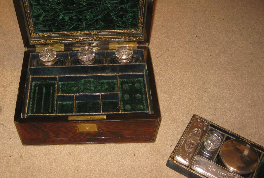 A rectangular Victorian dark rosewood vanity box featuring brass bound edges, a central brass cartouche, and a brass keyhole escutcheon. View III