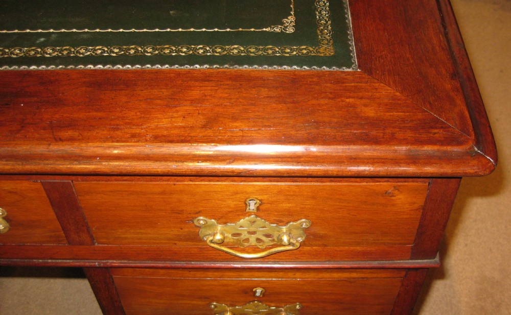 A Victorian walnut pedestal desk featuring nine drawers with decorative brass handles and a dark leather inset writing top. View VIII