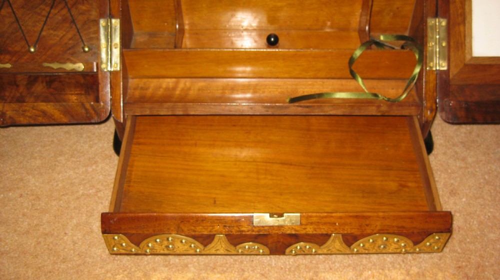 A Victorian burr walnut stationery cabinet featuring a sloped front adorned with ornate, studded brass strapwork mounts. View III