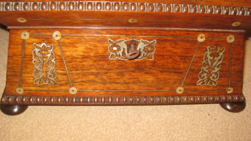 An antique sarcophagus-shaped rosewood sewing box featuring floral brass and mother-of-pearl inlays, carved gadrooned borders, and bun feet. View IV