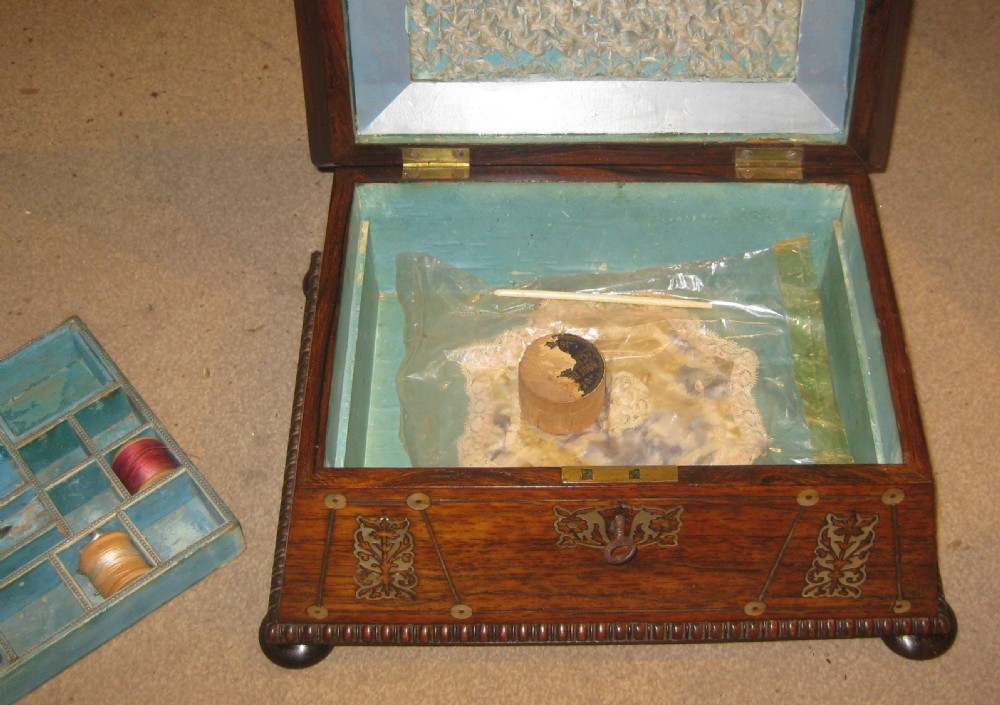 An antique sarcophagus-shaped rosewood sewing box featuring floral brass and mother-of-pearl inlays, carved gadrooned borders, and bun feet. View VI