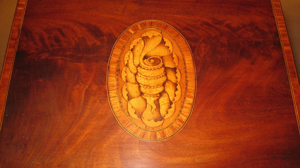 An 18th-century Georgian mahogany slope-front box featuring a serpentine front, crossbanded inlay borders, an oval shell marquetry medallion on the lid, and a brass keyhole escutcheon. View IV