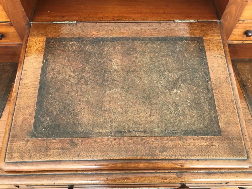A Victorian golden walnut Dickens desk featuring a central sloped leather writing surface flanked by raised side drawers and a spindle gallery above twin drawer pedestals. View VI