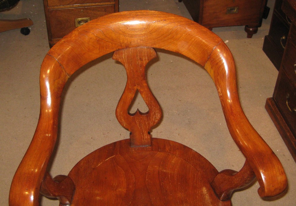 A Victorian walnut revolving desk chair featuring a continuous curved backrail, pierced vase splat, shaped saddle seat, and splayed legs. View XI