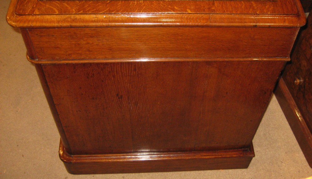 A Victorian oak pedestal desk featuring a leather-inlaid writing top, nine drawers with turned wooden knobs, and double plinth bases. View VIII