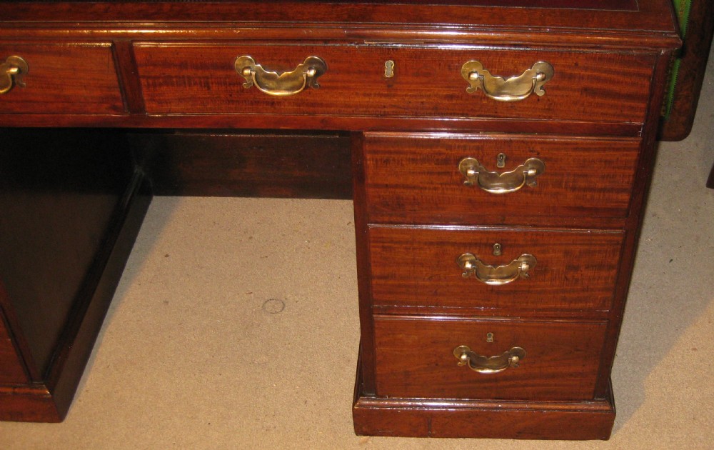 An 18th-century Georgian mahogany kneehole desk featuring a leather inset top, brass swan-neck handles, and flanking columns of drawers. View II