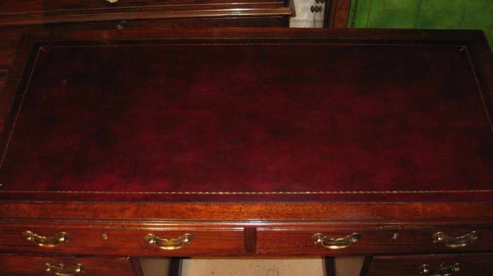 An 18th-century Georgian mahogany kneehole desk featuring a leather inset top, brass swan-neck handles, and flanking columns of drawers. View III
