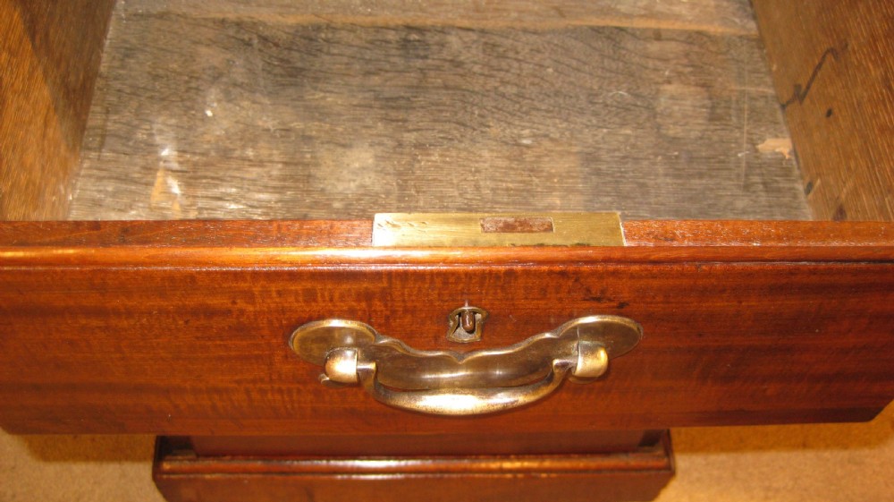 An 18th-century Georgian mahogany kneehole desk featuring a leather inset top, brass swan-neck handles, and flanking columns of drawers. View IX