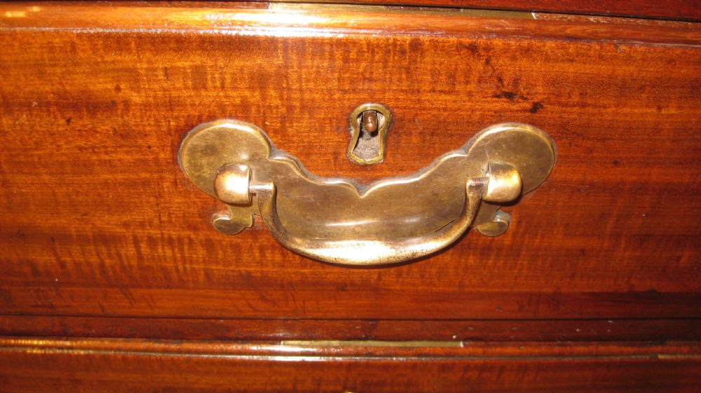 An 18th-century Georgian mahogany kneehole desk featuring a leather inset top, brass swan-neck handles, and flanking columns of drawers. View X