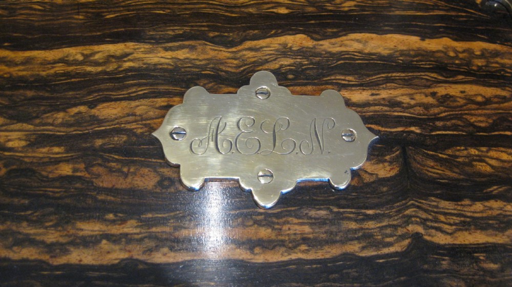 A rectangular Coromandel wood stationery box with polished brass strap hinges and a central keyhole escutcheon. View V