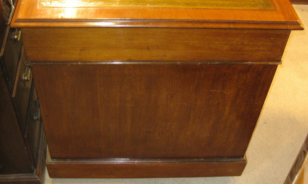 A late Victorian golden mahogany pedestal desk featuring nine drawers with brass handles and an inset leather writing top. View VI