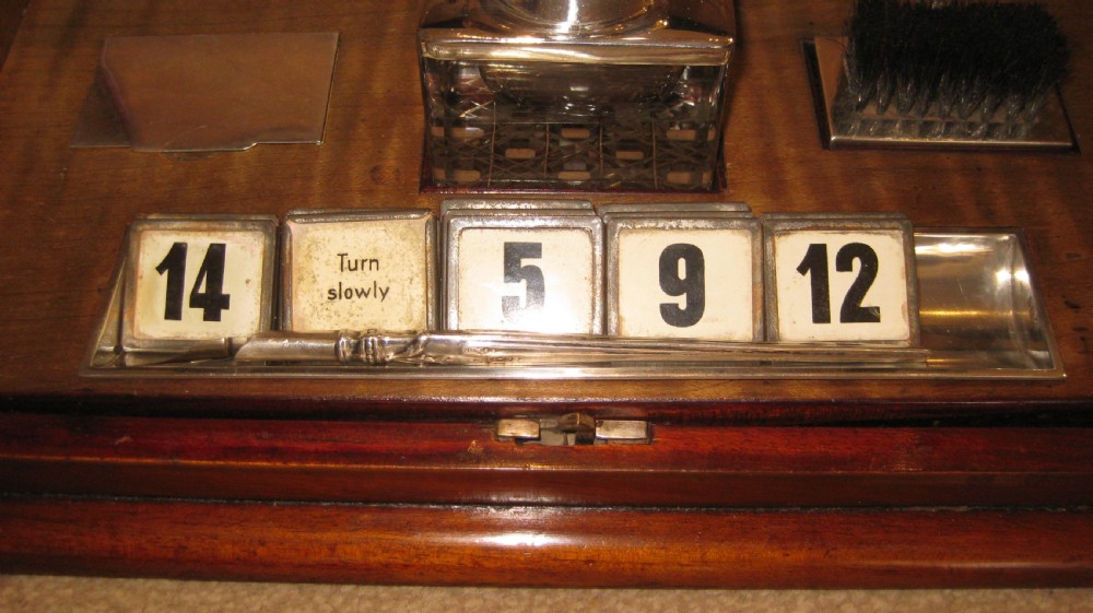 An antique mahogany stationery cabinet featuring a sloped double-door front with inlaid boxwood stringing and a central brass keyhole escutcheon. View IV