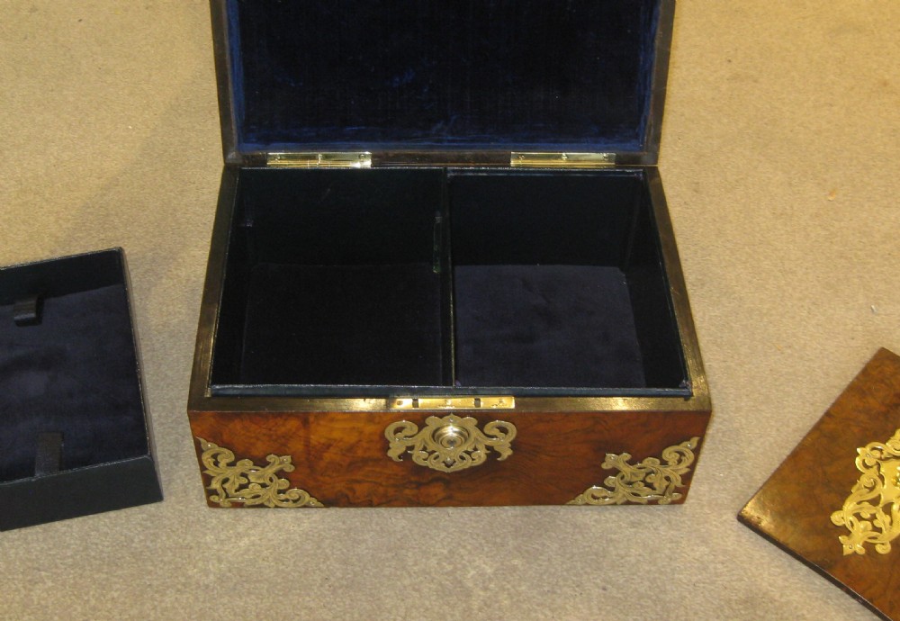 A domed Victorian burr walnut jewellery box featuring intricate pierced brass mounts, corner brackets, an escutcheon, and an upper handle. View V