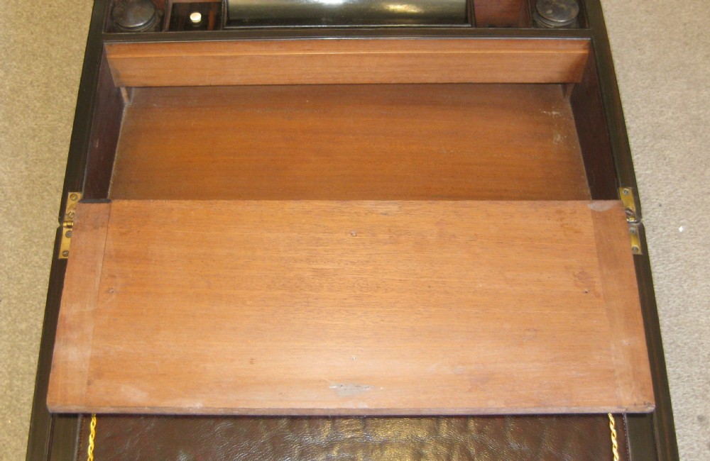 A closed rectangular dark mahogany writing box reinforced with brass straps, brass corner pieces, and a central brass keyhole. View VIII