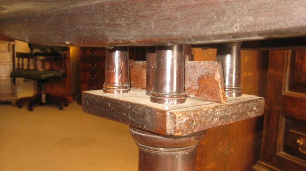 A Georgian mahogany tilt-top table shown with its circular top flipped vertically on a turned pedestal base with tripod cabriole legs. View V