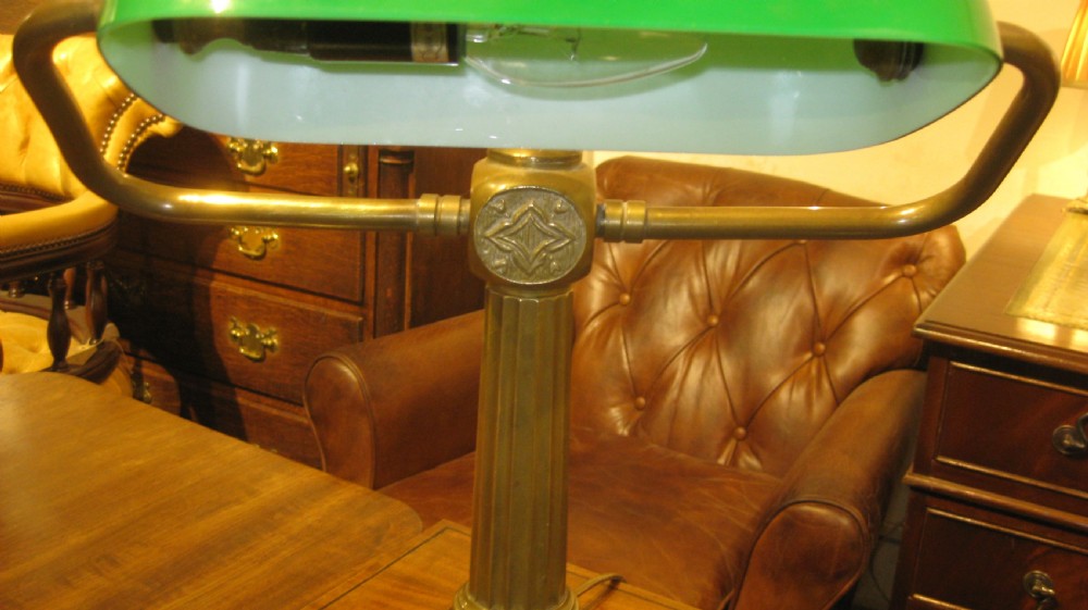 An adjustable brass desk lamp featuring a reeded stem, stepped square base, and a green glass shade. View III