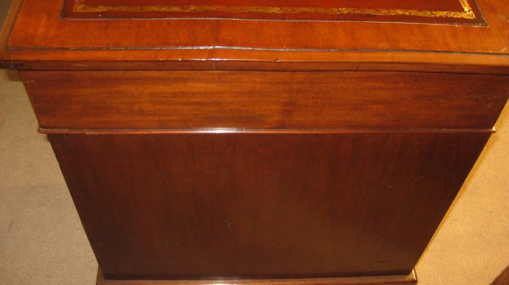 A late Victorian walnut pedestal desk featuring a gilt-tooled brown leather writing surface, nine drawers with ornate brass handles, and twin pedestals resting on plinth bases. View VIII