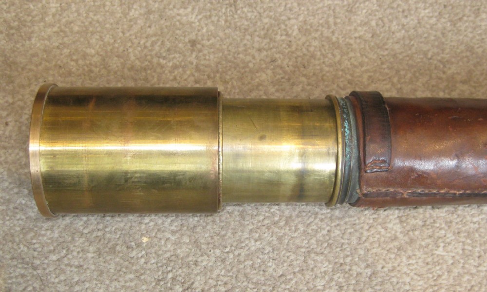 An extended four-draw antique brass telescope featuring a central stitched leather barrel sleeve. View II