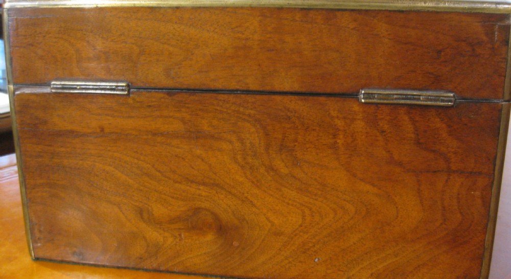 A Victorian rectangular burr walnut box featuring brass edges, a central brass cartouche, a keyhole escutcheon, and a lower drawer. View IV