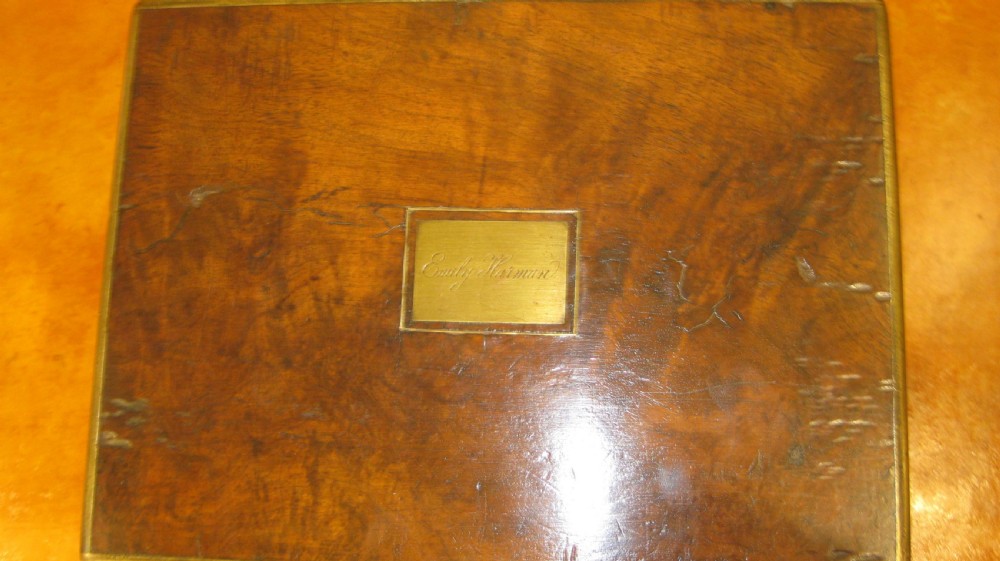 A Victorian rectangular burr walnut box featuring brass edges, a central brass cartouche, a keyhole escutcheon, and a lower drawer. View VII