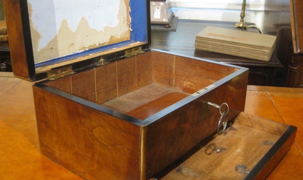 A Victorian rectangular burr walnut box featuring brass edges, a central brass cartouche, a keyhole escutcheon, and a lower drawer. View XII