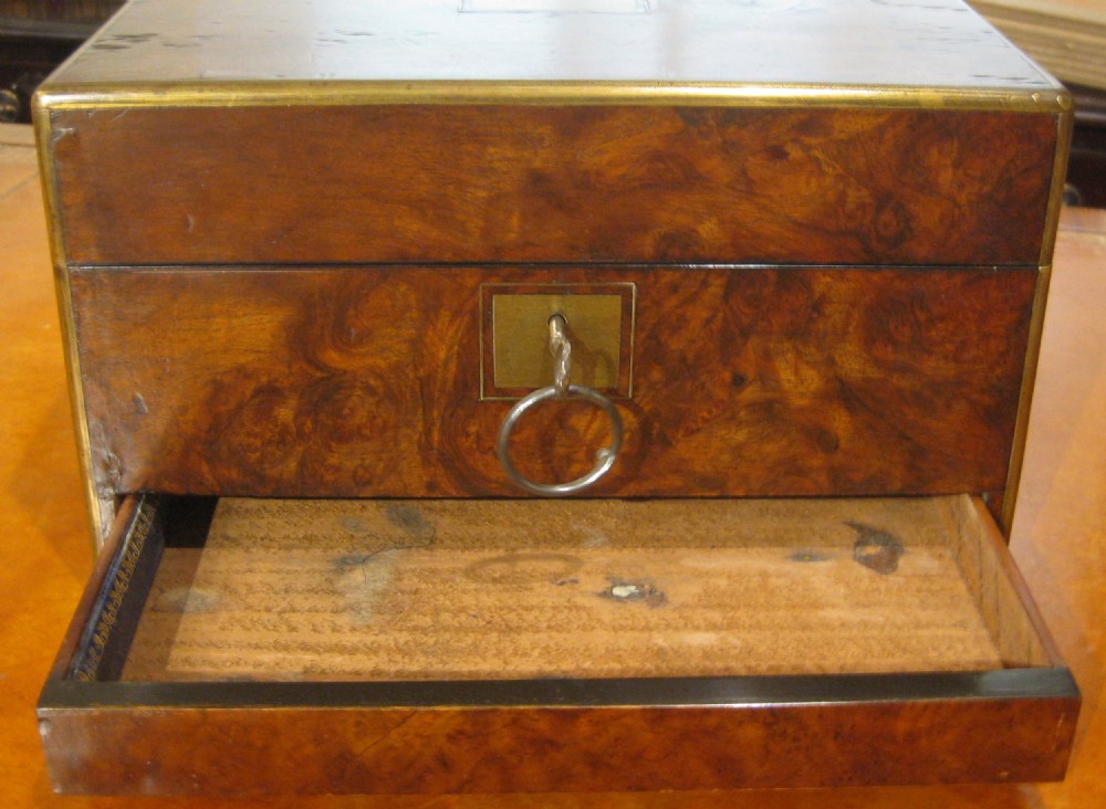 A Victorian rectangular burr walnut box featuring brass edges, a central brass cartouche, a keyhole escutcheon, and a lower drawer. View XIV