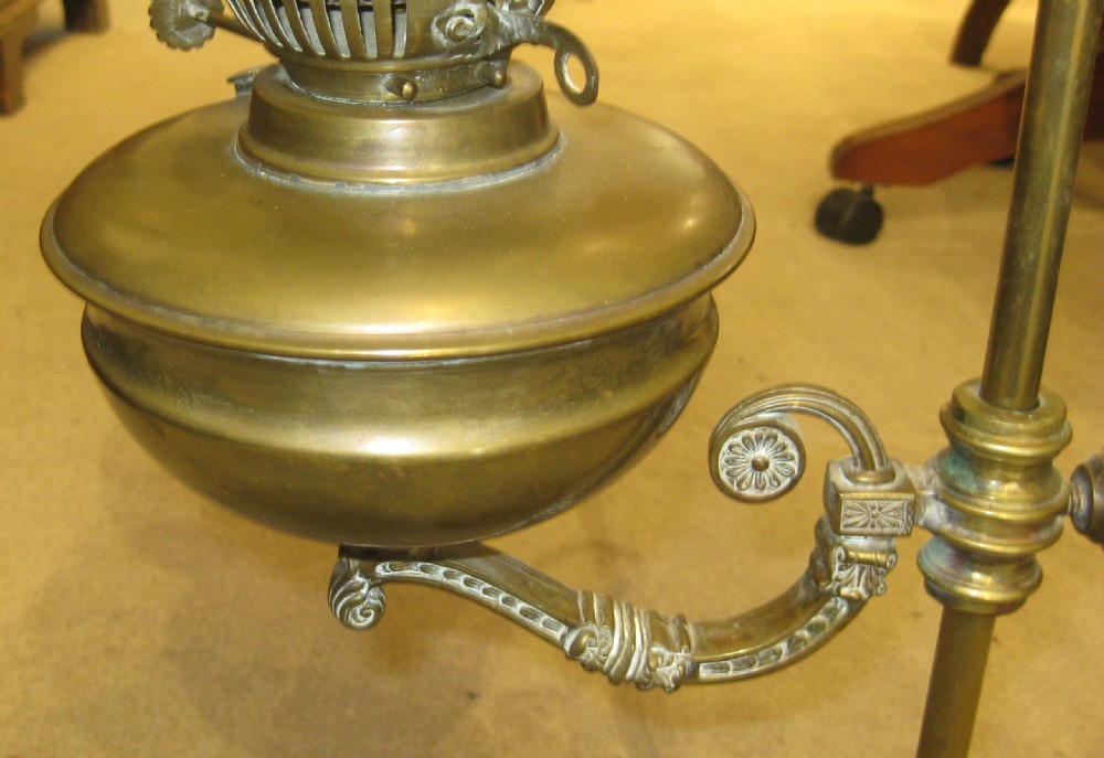 An antique Victorian brass oil lamp featuring an adjustable arm stand, circular base, frosted etched glass globe, and a pink crimped glass rim shade. View III