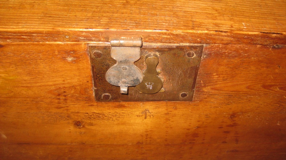 A rectangular solid pine storage trunk featuring iron corner brackets and a central metal lock mechanism with key. View II