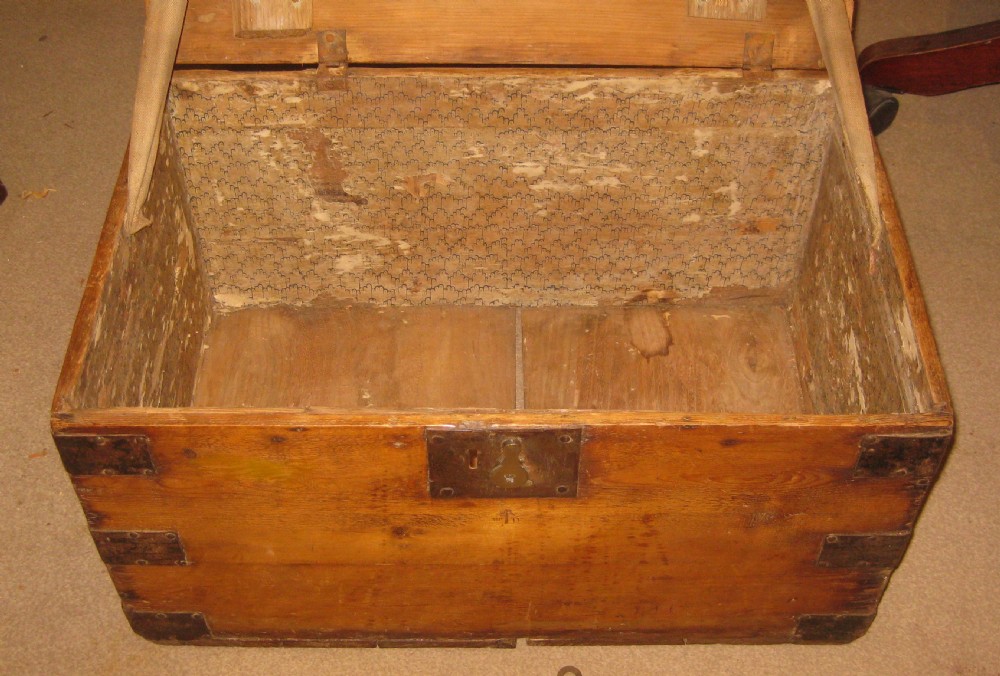 A rectangular solid pine storage trunk featuring iron corner brackets and a central metal lock mechanism with key. View IV