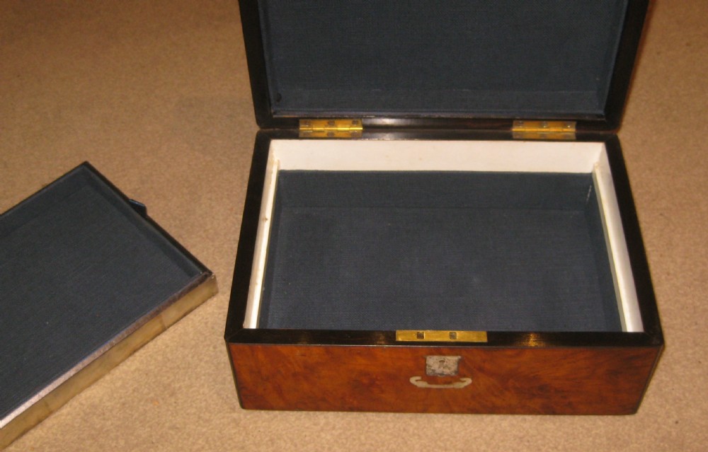 A rectangular Victorian box crafted from warm brown burr walnut veneer with an inlaid central shield plaque and keyhole escutcheon. View III