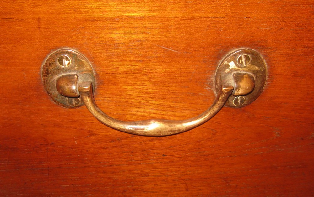 A rectangular Victorian solid teak wooden trunk featuring a hinged top lid, a central flush brass catch, and a keyhole on the front panel. View IX