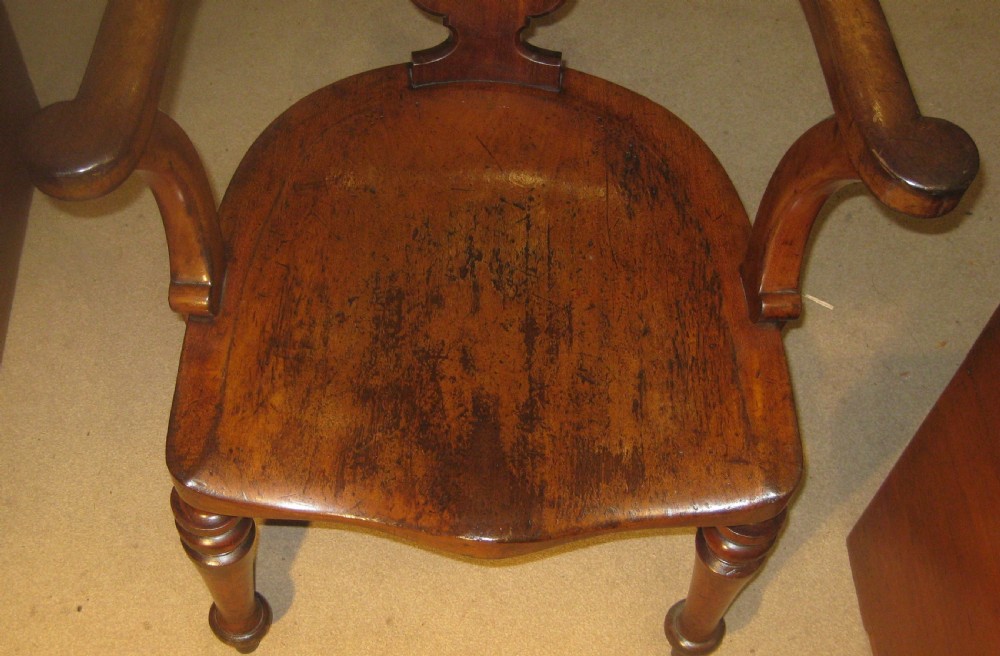 A Victorian mahogany Captains desk chair featuring a curved crest rail, pierced back splat, patinated leather seat, and turned front legs. View VI