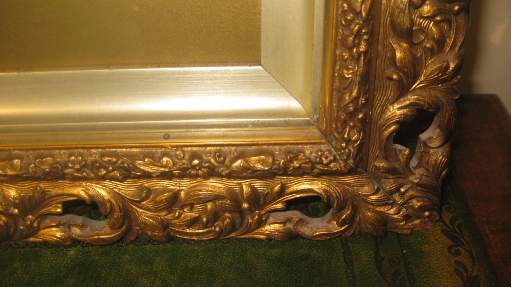 A late Victorian watercolour portrait depicting a young woman wearing a blue hat and dress set within an oval mount and heavily carved gilt frame. View IV