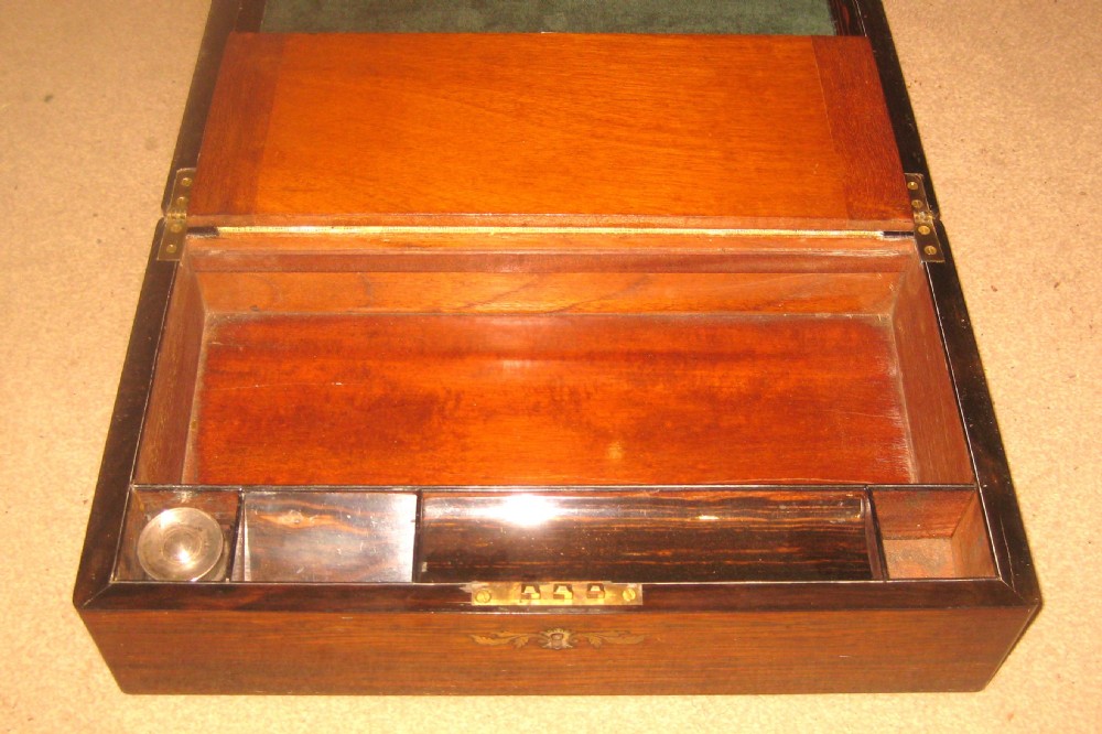 A rectangular Victorian rosewood writing slope featuring a figured grain finish with a central foliate inlay on the lid and an inlaid escutcheon on the front. View IV