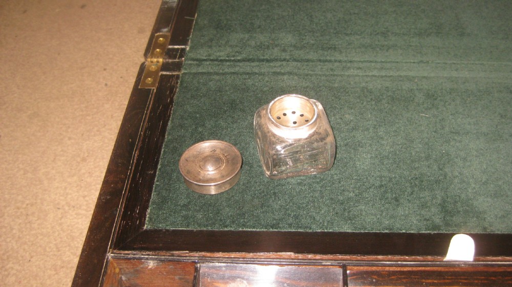 A rectangular Victorian rosewood writing slope featuring a figured grain finish with a central foliate inlay on the lid and an inlaid escutcheon on the front. View V