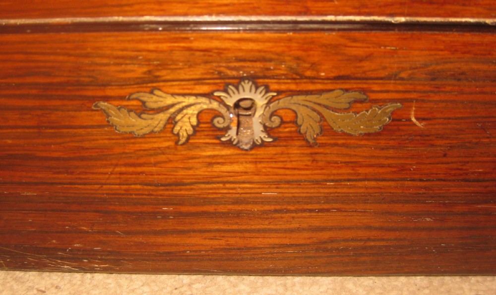 A rectangular Victorian rosewood writing slope featuring a figured grain finish with a central foliate inlay on the lid and an inlaid escutcheon on the front. View VII