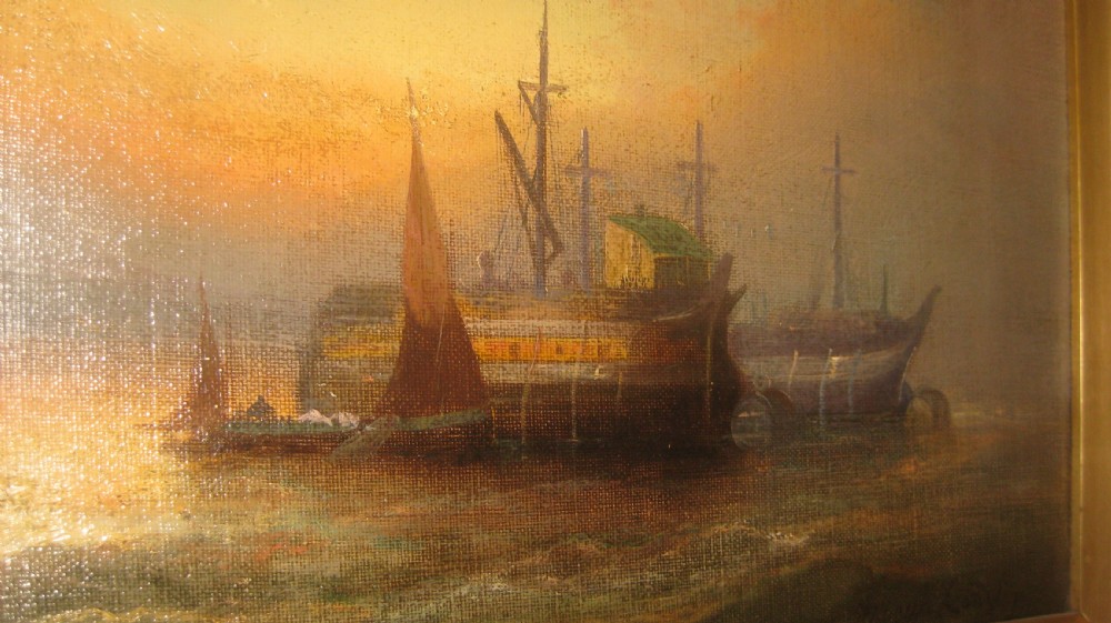 A framed oil painting depicting historic wooden ships anchored at sunset with a gilded ornate frame. View II