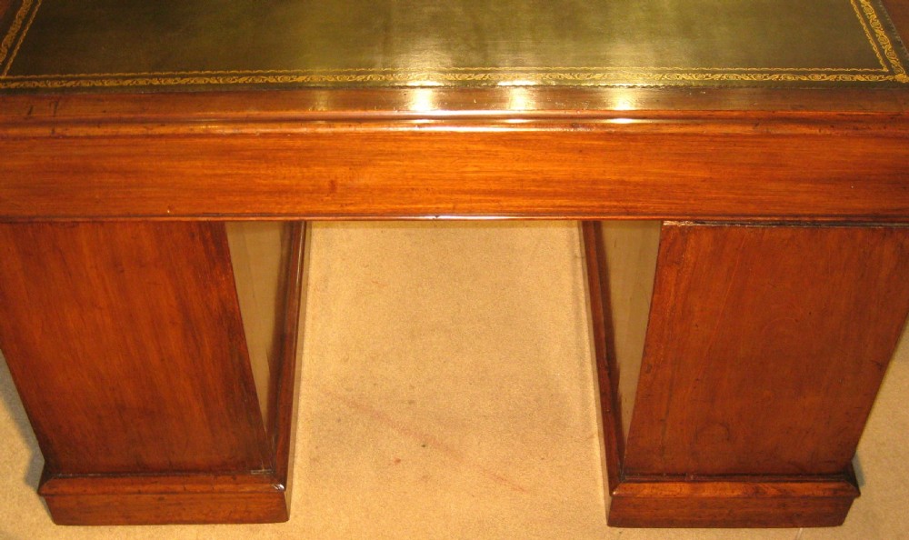 A Victorian mahogany pedestal desk featuring a green leather writing surface insert and nine storage drawers with brass knobs. View X