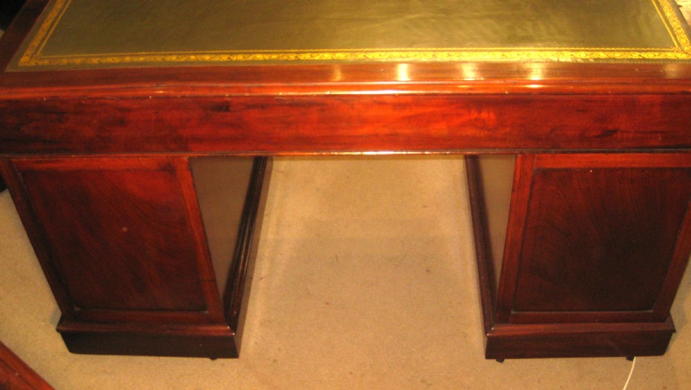A Victorian mahogany pedestal desk featuring nine drawers with turned handles, rounded corners, and a green leather insert. View VIII
