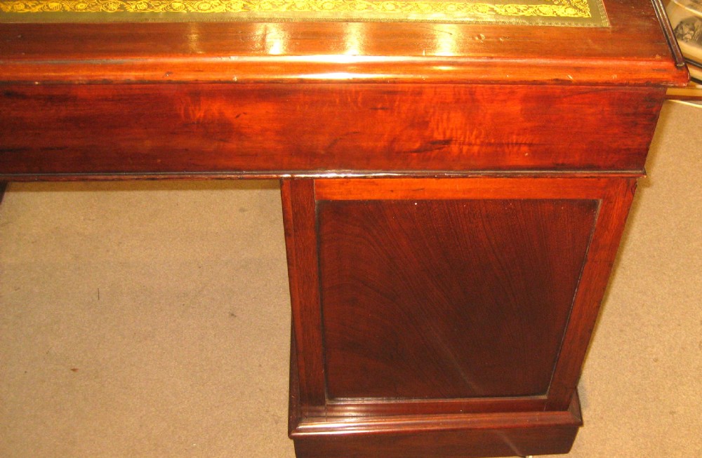 A Victorian mahogany pedestal desk featuring nine drawers with turned handles, rounded corners, and a green leather insert. View IX