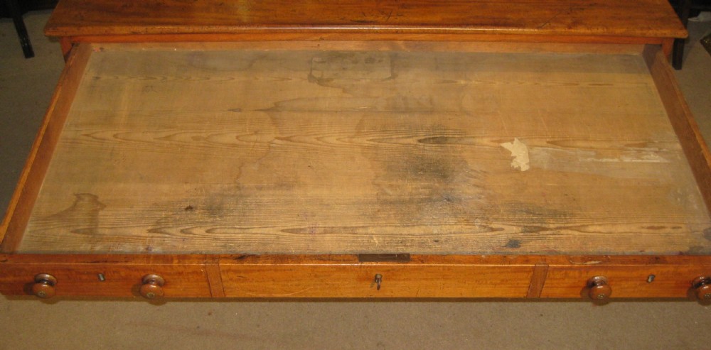 A Victorian golden mahogany pedestal desk featuring nine drawers with turned wooden knobs around a central kneehole. View V