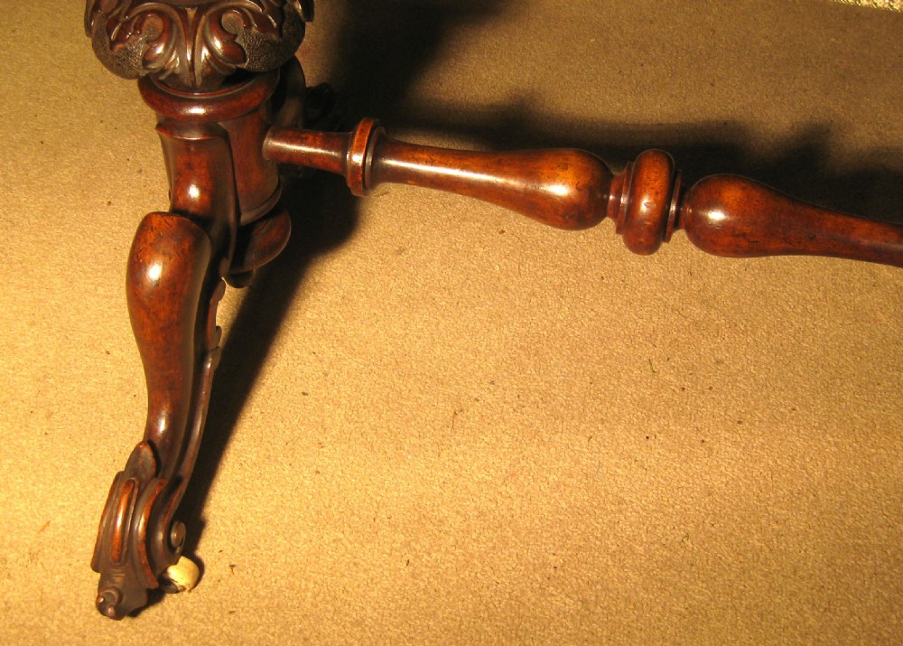 A Victorian burr walnut games and sewing table featuring a serpentine fold-over top, carved turned supports, a single drawer, and a fabric-covered work basket below. View VII