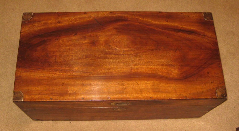A rectangular solid camphorwood campaign trunk featuring visible wood grain, corner brass brackets, and a flush inset brass handle. View II