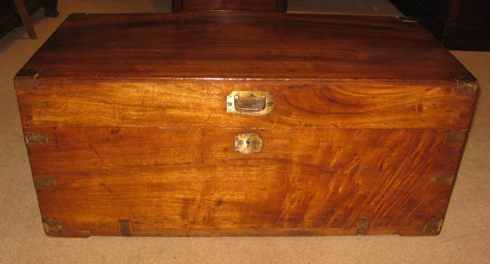 A rectangular solid camphorwood campaign trunk featuring visible wood grain, corner brass brackets, and a flush inset brass handle. View III