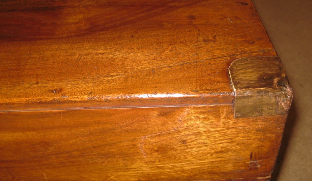 A rectangular solid camphorwood campaign trunk featuring visible wood grain, corner brass brackets, and a flush inset brass handle. View IV