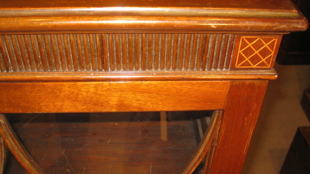 A Victorian dark mahogany glazed cabinet featuring double doors with gothic arch astragal glazing bars and bracket feet. View II